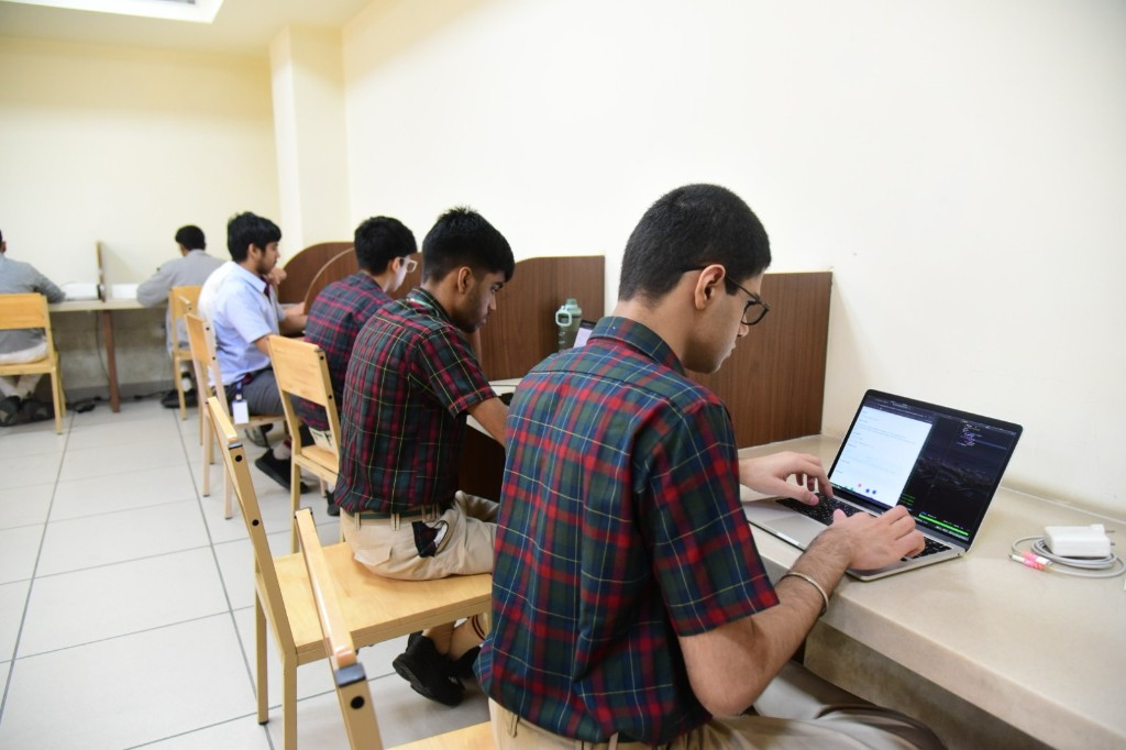Students coding at partitioned desks in the computer lab during a live Techathlon challenge