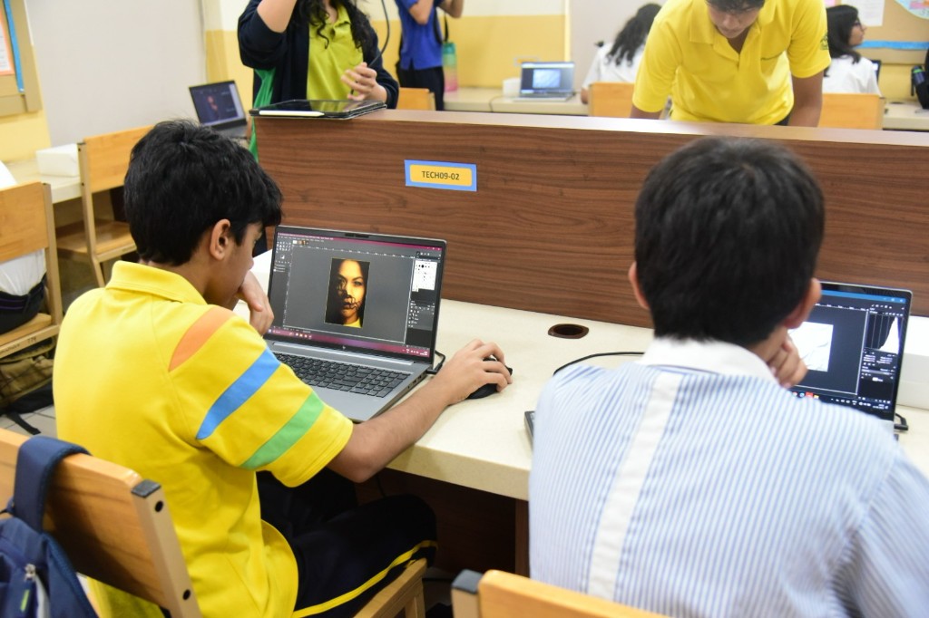 Students at laptops editing photos during the Through the Lens challenge at workstation TECH09-02