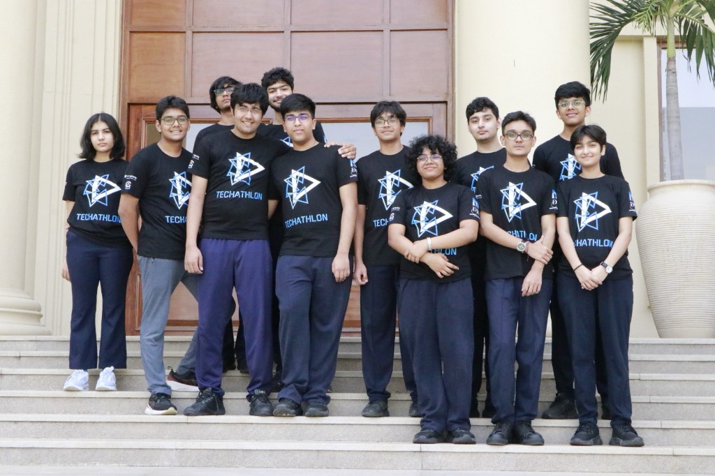 Techathlon team members posing together in matching event t-shirts on the school steps